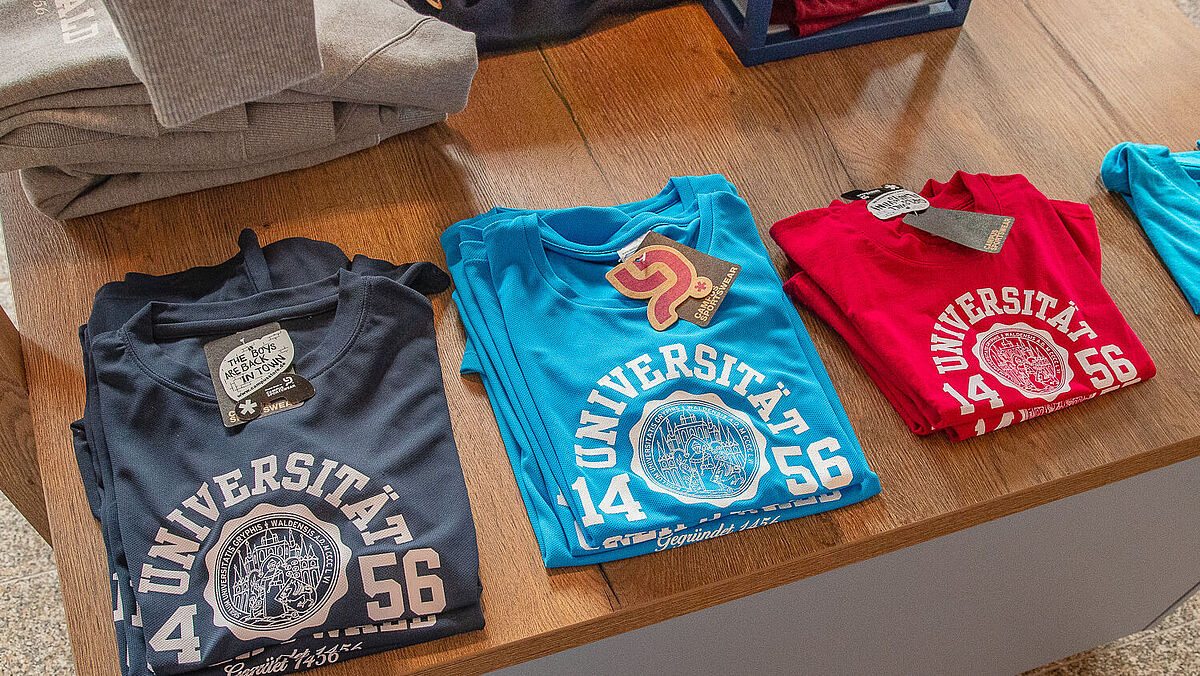 Im Uniladen liegen T-Shirts im Regal.