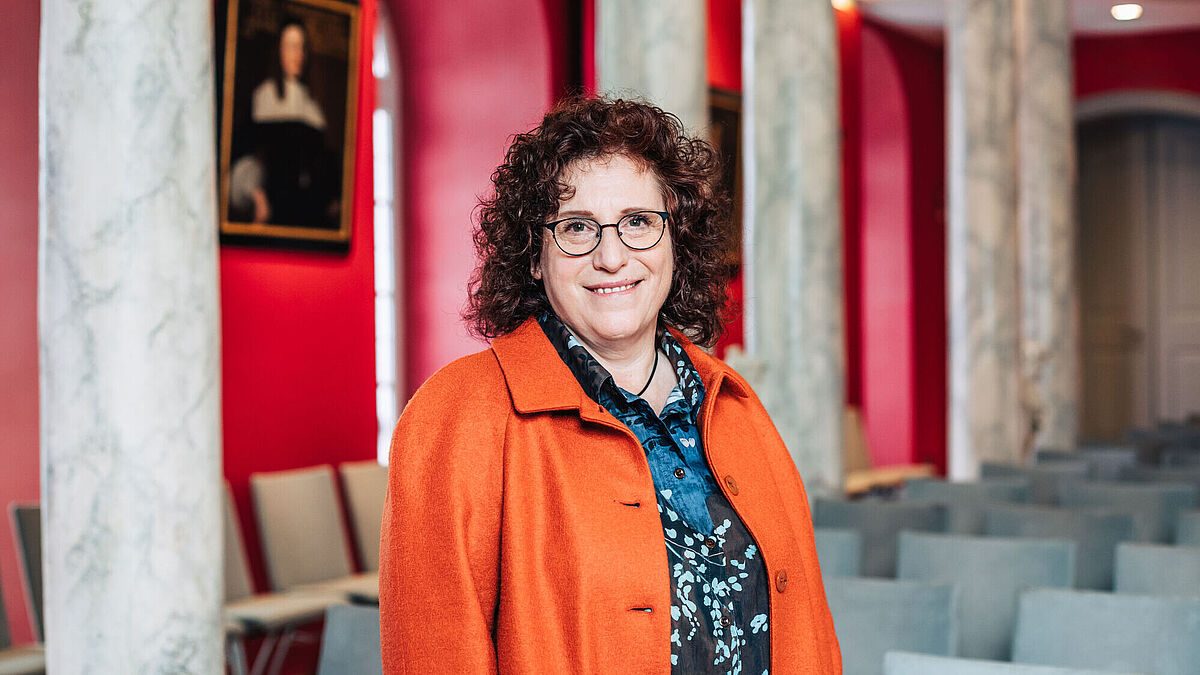 The photo is a portrait of Rector of the University of Greifswald, Prof. Dr. Katharina Riedel, in the Aula